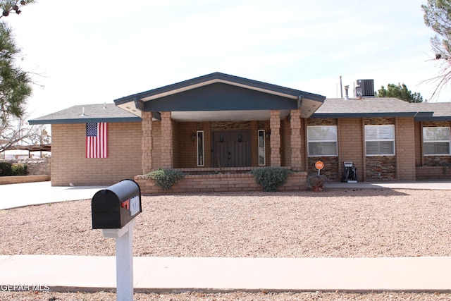 ranch-style home with cooling unit and brick siding