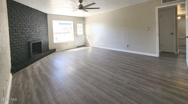 unfurnished living room featuring visible vents, a ceiling fan, a textured ceiling, dark wood-style floors, and a fireplace