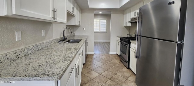 kitchen featuring baseboards, a sink, stainless steel appliances, white cabinets, and under cabinet range hood