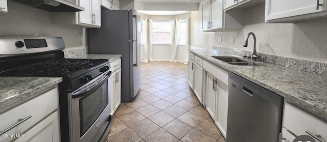 kitchen with white cabinetry, ventilation hood, appliances with stainless steel finishes, and a sink