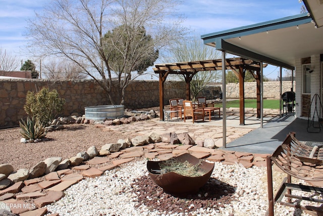 view of yard featuring a patio area, a fenced backyard, a pergola, and a fire pit