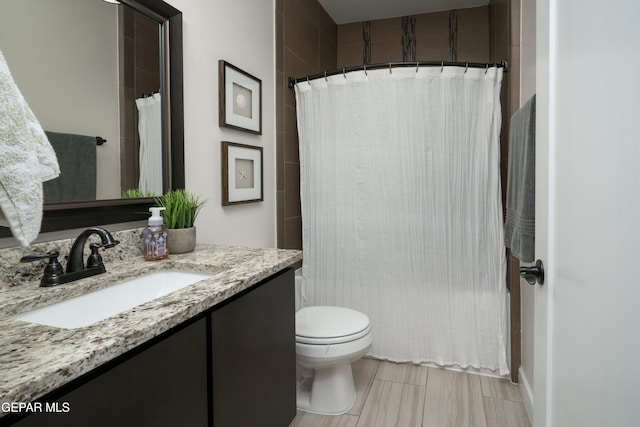 full bath featuring a shower with curtain, vanity, and toilet