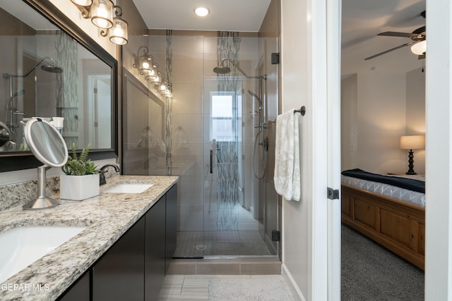 bathroom featuring connected bathroom, a sink, a ceiling fan, a shower stall, and double vanity