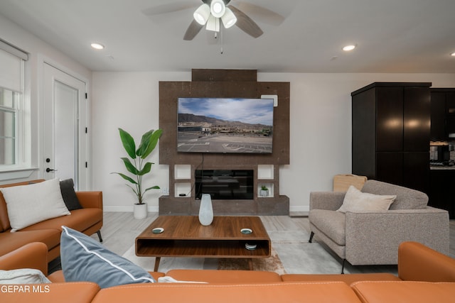 living room with recessed lighting, a large fireplace, ceiling fan, wood finished floors, and baseboards