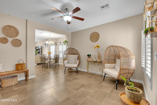 sitting room featuring ceiling fan with notable chandelier, visible vents, and baseboards