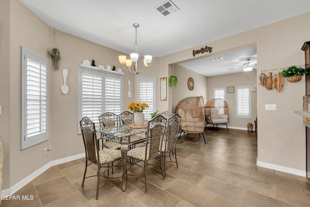 dining space featuring ceiling fan with notable chandelier, visible vents, and baseboards