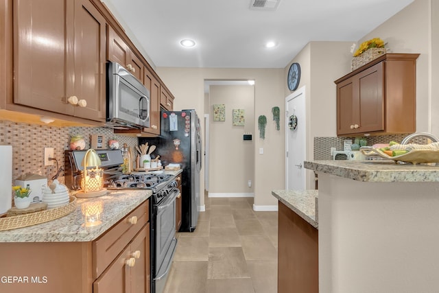 kitchen featuring stainless steel appliances, recessed lighting, decorative backsplash, light stone countertops, and baseboards