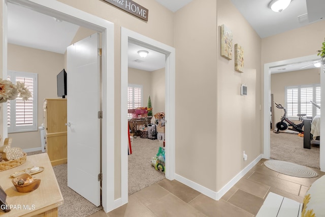 hallway with carpet floors, a wealth of natural light, and baseboards