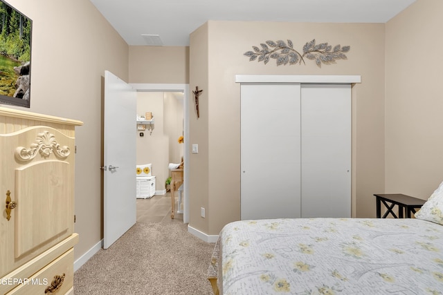 bedroom featuring light carpet, a closet, and baseboards