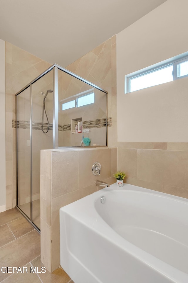 bathroom featuring a garden tub and a shower stall