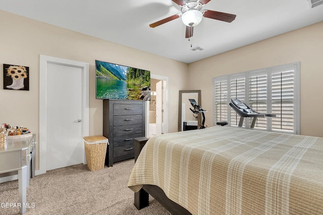 bedroom featuring ceiling fan, ensuite bathroom, visible vents, and light colored carpet