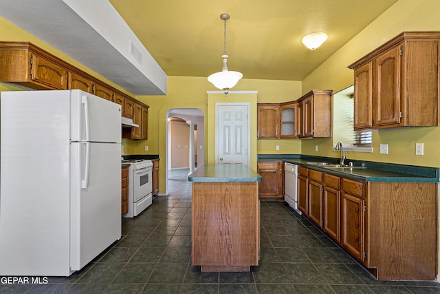 kitchen featuring white appliances, visible vents, arched walkways, a sink, and a center island