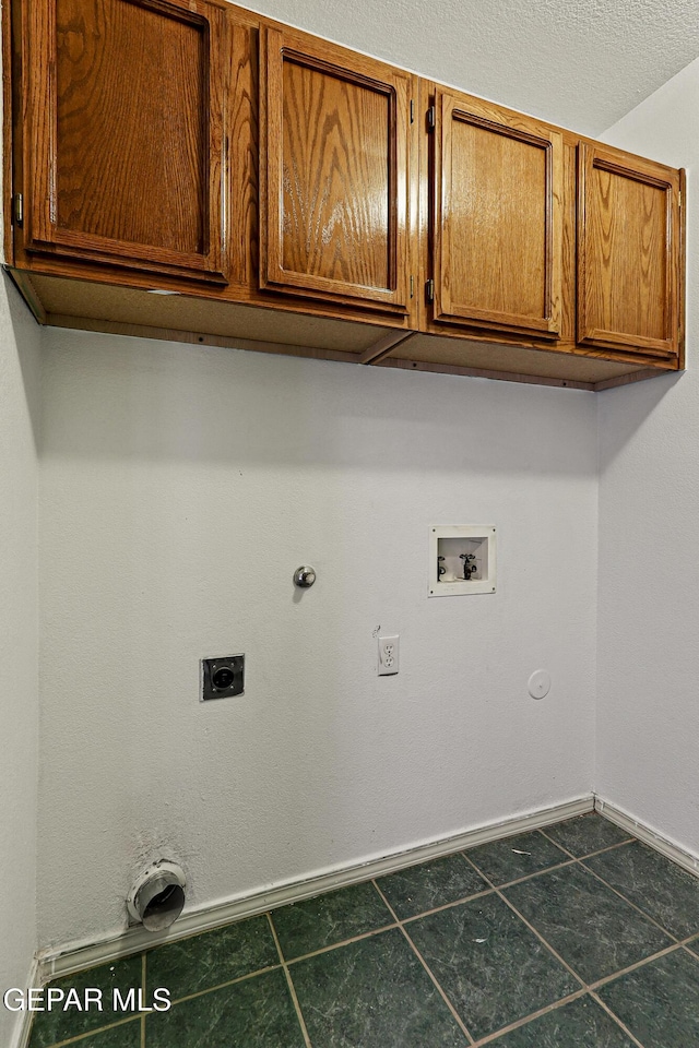 clothes washing area featuring baseboards, gas dryer hookup, washer hookup, cabinet space, and electric dryer hookup