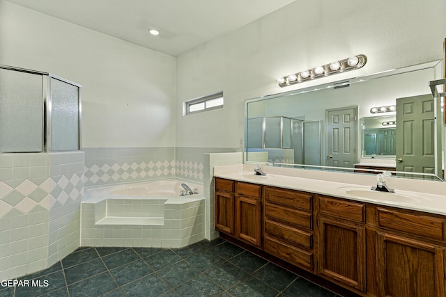 full bath with a garden tub, double vanity, a stall shower, tile patterned floors, and a sink