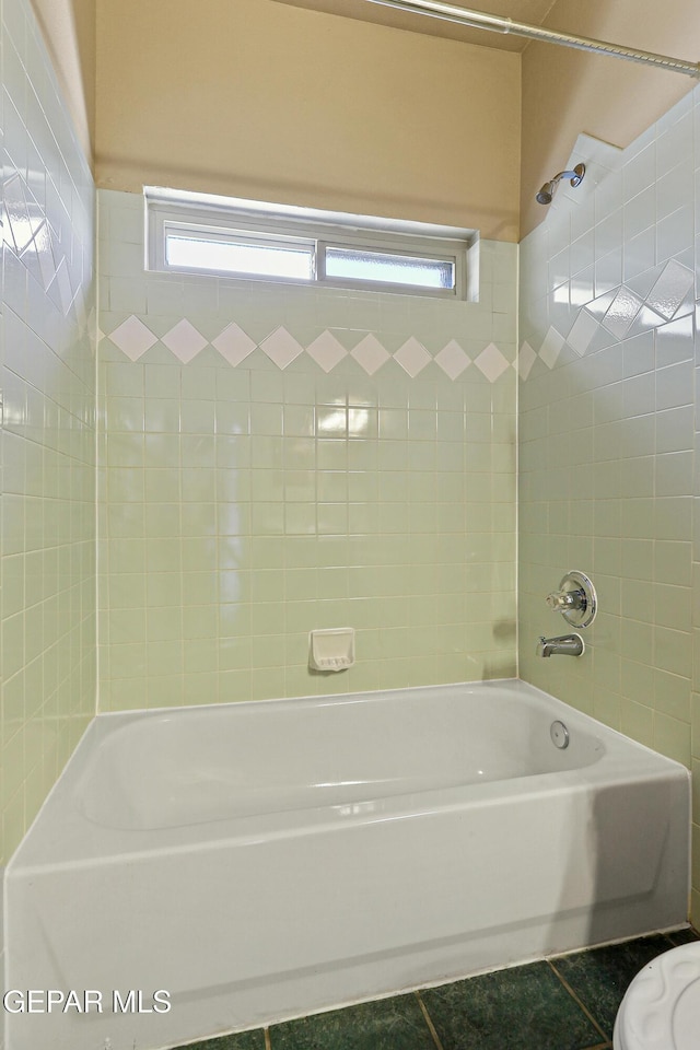 bathroom featuring tile patterned floors, toilet, and shower / bathtub combination