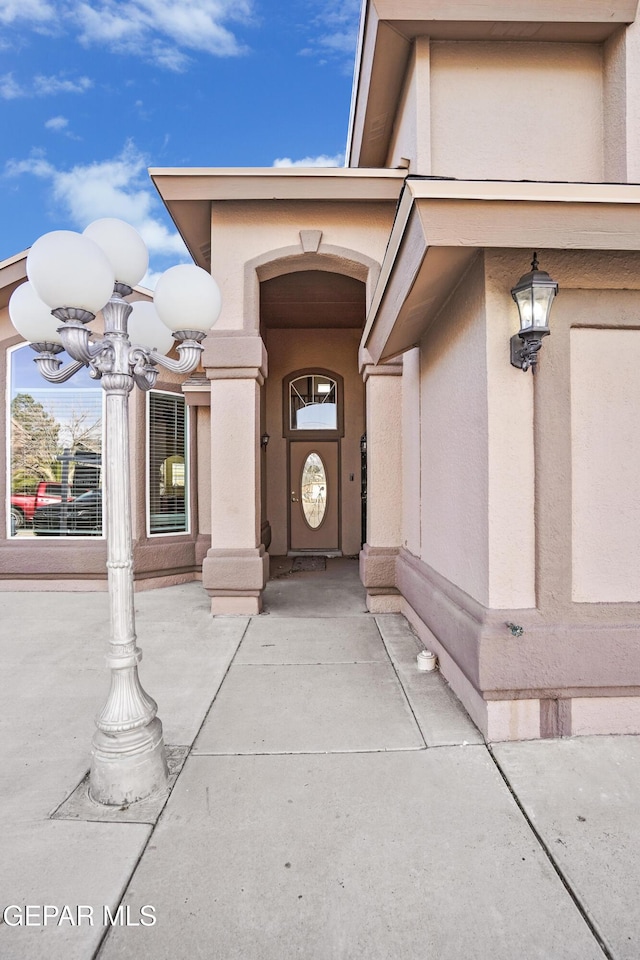 entrance to property featuring stucco siding