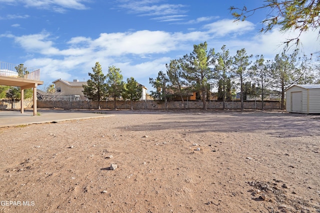 view of yard with a storage shed, fence, and an outdoor structure