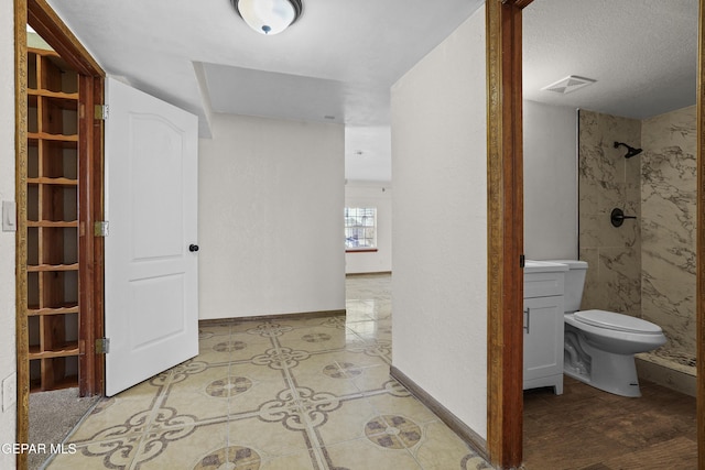 hallway with baseboards and visible vents