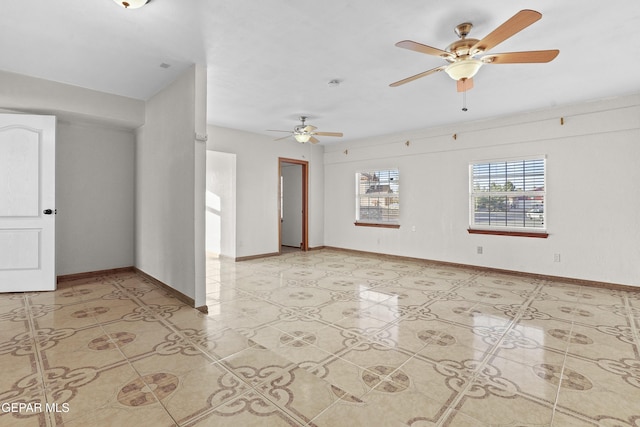 spare room with light tile patterned floors, a ceiling fan, and baseboards