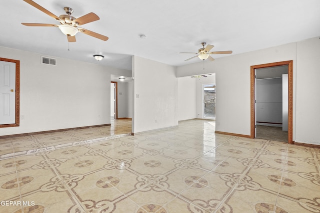 empty room featuring visible vents, ceiling fan, and baseboards