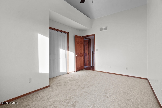 unfurnished bedroom featuring carpet, visible vents, baseboards, ceiling fan, and a closet