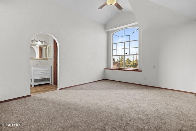 unfurnished bedroom featuring high vaulted ceiling, a ceiling fan, baseboards, and carpet floors