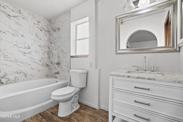 bathroom with vanity, baseboards, wood finish floors, shower / bath combination, and toilet