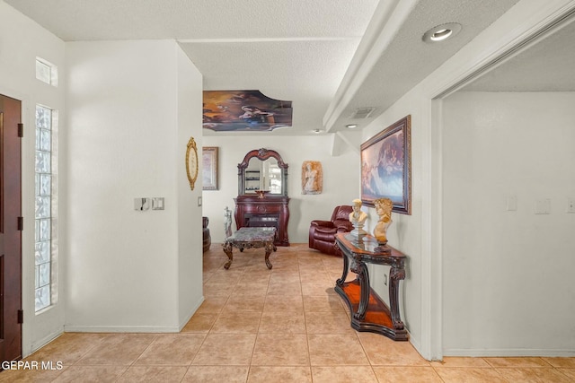 interior space featuring light tile patterned floors, visible vents, and a textured ceiling