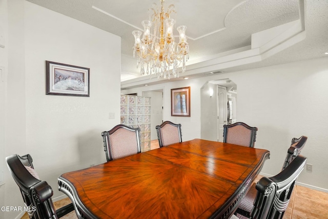 tiled dining area featuring visible vents, arched walkways, a raised ceiling, baseboards, and a chandelier