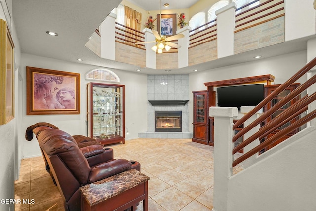 living room with tile patterned flooring, stairway, and a tiled fireplace