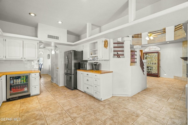 kitchen featuring wine cooler, butcher block counters, visible vents, appliances with stainless steel finishes, and white cabinets