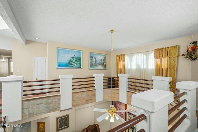 interior space with ceiling fan and a textured ceiling