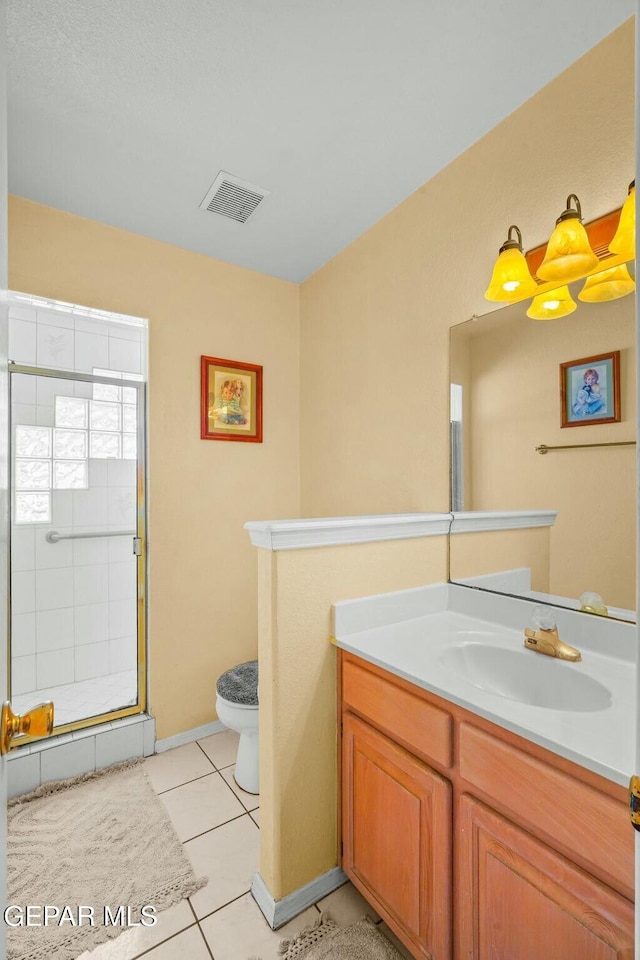 bathroom with a stall shower, visible vents, toilet, tile patterned floors, and vanity