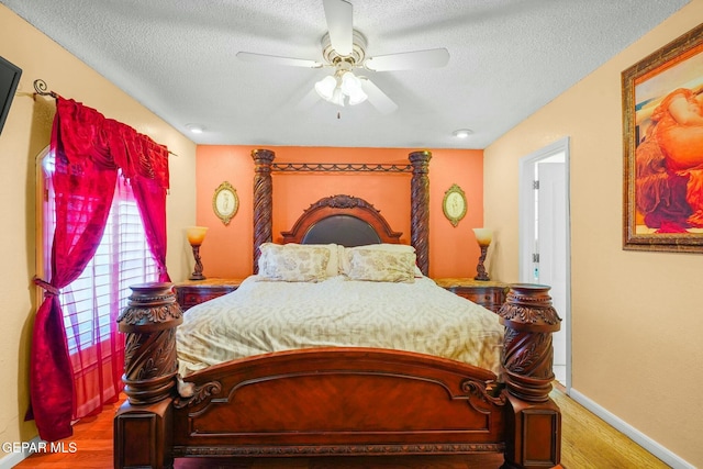 bedroom with ceiling fan, a textured ceiling, baseboards, and wood finished floors