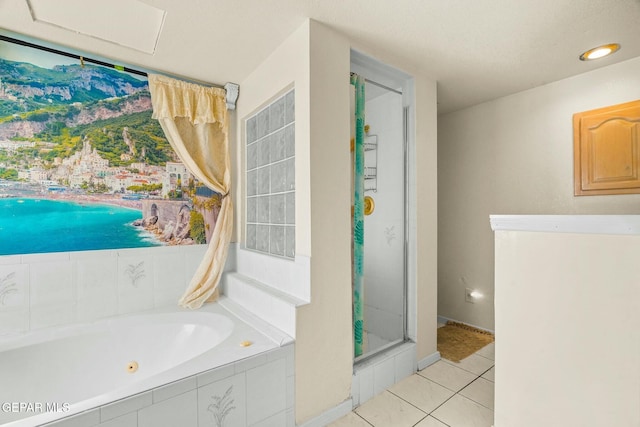 bathroom featuring a stall shower, a tub with jets, and tile patterned floors