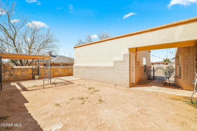 view of yard with a patio, fence, and a gate