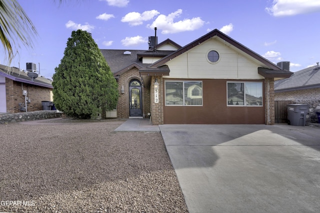 view of front facade with central AC and brick siding