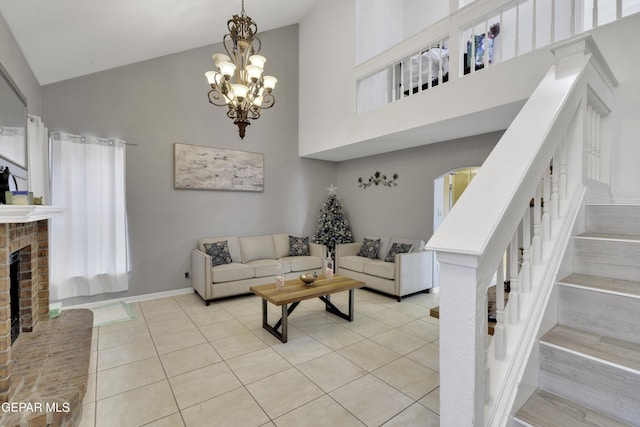 tiled living room featuring baseboards, stairway, a brick fireplace, high vaulted ceiling, and a notable chandelier