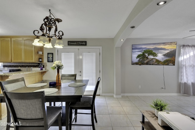 dining space with french doors, a notable chandelier, recessed lighting, light tile patterned flooring, and baseboards