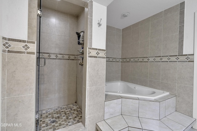 bathroom with a shower stall, tile walls, and a bath