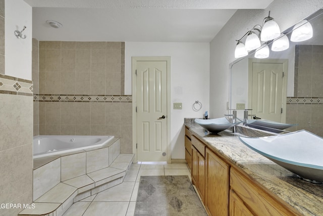 full bathroom featuring tiled bath, tile patterned flooring, a sink, and tile walls