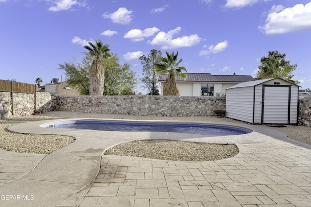 view of swimming pool with a storage shed, a fenced in pool, a fenced backyard, an outdoor structure, and a patio area