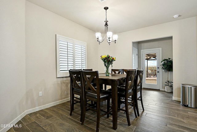 dining area with a notable chandelier, dark wood finished floors, and baseboards