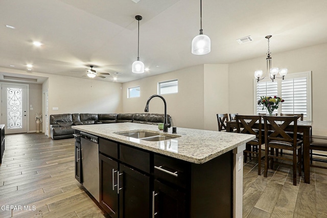 kitchen with decorative light fixtures, light wood finished floors, visible vents, a sink, and dishwasher