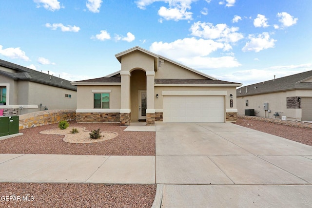 view of front of property with driveway, central AC unit, stone siding, an attached garage, and stucco siding