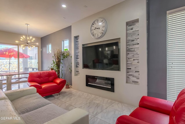 living area with marble finish floor, recessed lighting, a glass covered fireplace, and a notable chandelier