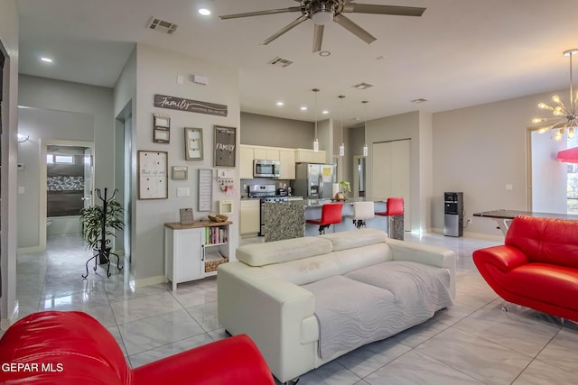 living room with ceiling fan with notable chandelier, baseboards, visible vents, and recessed lighting