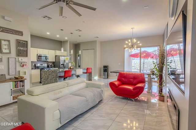 living area featuring visible vents and ceiling fan with notable chandelier