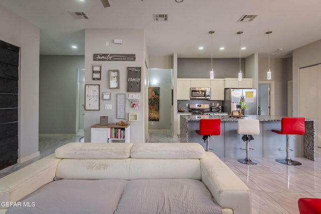 living area featuring visible vents and recessed lighting