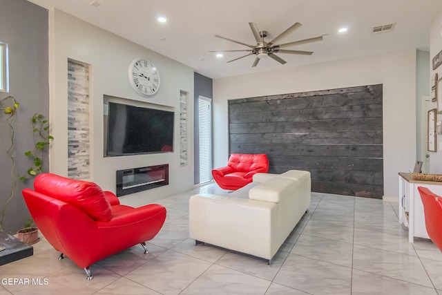 living area featuring a ceiling fan, a glass covered fireplace, visible vents, and recessed lighting